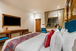 a bedroom with a large white bed with red pillows at Sterling Rudraksh Jaisalmer in Jaisalmer