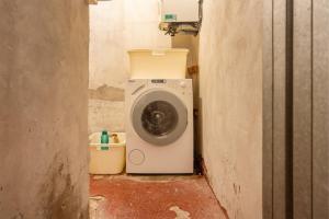 a washing machine sitting in a corner of a room at Casa Claudia, stylish & spacious in Nago-Torbole