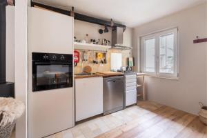 a kitchen with white appliances and a window at Casa Claudia, stylish & spacious in Nago-Torbole