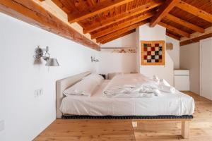 a bedroom with a bed in a room with wooden ceilings at Casa Claudia, stylish & spacious in Nago-Torbole