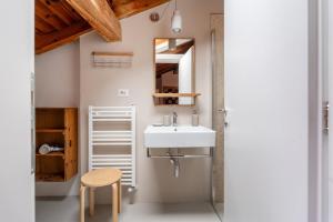 a bathroom with a sink and a wooden stool at Casa Claudia, stylish & spacious in Nago-Torbole +37 photos