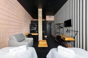 a room with two beds and a couch and a desk at Apartamentos HEY U in Murcia +42 photos
