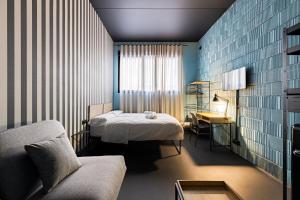 a bedroom with a bed and a couch and a table at Apartamentos HEY U in Murcia