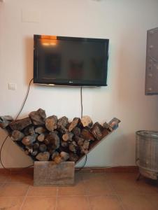 a pile of logs and a tv on a wall at Casa Manuela in Busquístar