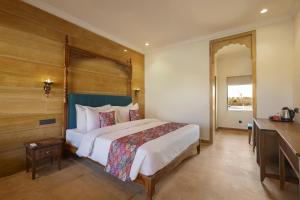 a bedroom with a bed and a desk in a room at Sterling Rudraksh Jaisalmer in Jaisalmer