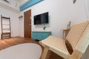a living room with two chairs and a flat screen tv at 山沐三薰 2館 可包棟含蔬食早餐 in Shangwu +20 photos