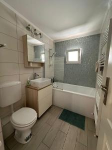 a bathroom with a toilet and a tub and a sink at Rose Peony in Cluj-Napoca