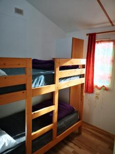 two bunk beds in a room with a window at Mobil Home 4 pers proche Puy du Fou et Montaigu (Vendée 85) in La Boissière-de-Montaigu