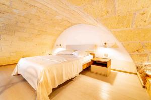 A bed or beds in a room at Il Melograno - Suite Deluxe