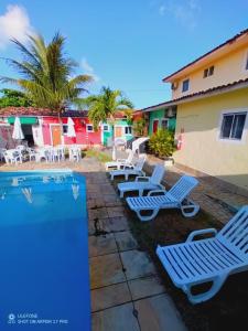 a group of lounge chairs next to a swimming pool at Pousada Maceio Inn in Maceió