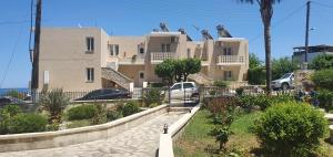 a large house with cars parked in front of it at Sofia Apartments SEA VIEW in Georgioupolis