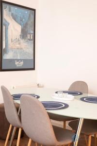 une table avec quatre chaises et une télévision sur un mur dans l'établissement Functional 3city Apartment in Sopot with Parking by Noclegi Renters, à Sopot