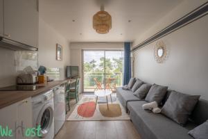 Una sala de estar con un sofá y una cocina. en TAMARIS -Proche mer-2p, en La Baule