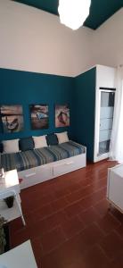 a room with a bed with a blue wall at Retrò Rooms in Cefalù
