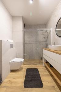a bathroom with a shower and a toilet and a sink at VIP Apartamenty Borowa in Rzeszów +32 photos