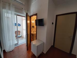 a room with a door and a television on the wall at Retrò Rooms in Cefalù