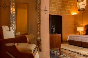 a bedroom with a bed and a chair in a room at Palazzo Presta in Gallipoli