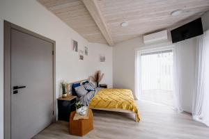 a bedroom with a bed with a yellow blanket at Sea Bees vacation homes in Ragaciems