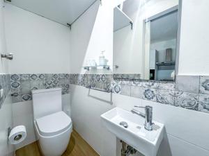 a white bathroom with a toilet and a sink at Luxury Allegra’s home in Siracusa