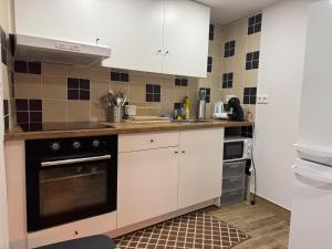 a kitchen with white cabinets and a stove top oven at Casa da Barragem in Negrões