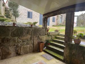 a stone wall with stairs and potted plants at Casa da Barragem in Negrões
