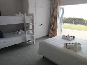 a bedroom with two bunk beds and a large window at Coral Tides -18 sleeper Beach house in Port Shepstone +21 photos