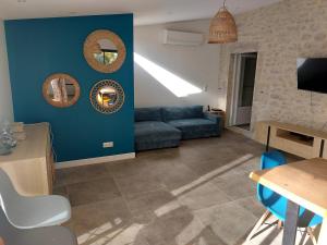 a living room with a blue couch and a table at Au coeur des vignes in Grospierres