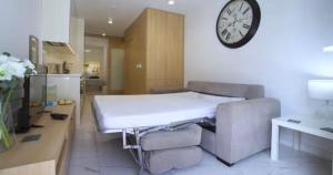 a room with a bed and a clock on the wall at Lubina del Sol beachfront in Mijas Costa