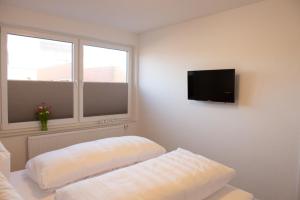 a room with two pillows and a tv on a wall at Deichhaus hinten in Norden