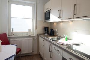 a kitchen with white cabinets and a sink and a window at Bounty in Norden