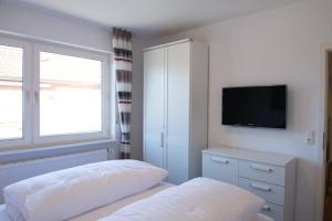 a bedroom with a bed and a tv on the wall at Bounty in Norden