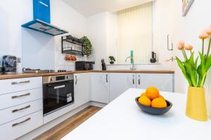 a white kitchen with a bowl of oranges on a counter at jaysapartment III in Aberdeen