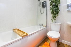a bathroom with a toilet and a tub and a sink at jaysapartment III in Aberdeen