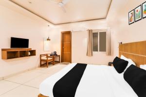 a bedroom with a large bed and a television at Super Townhouse Viraj Khand Formerly Veridian Inn in Lucknow
