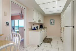 卫星海滩You Cannot Get Any Closer To The Beach! 2br Condo的厨房配有白色橱柜和白色冰箱 更多7张照片