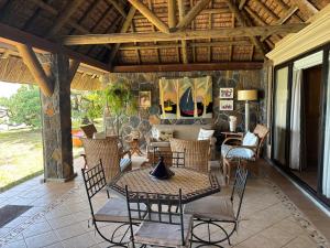 a screened in porch with a table and chairs at Villa Helios à Belle Mare in Post of Flacq