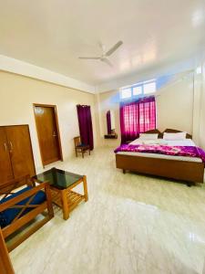 a large bedroom with a bed and a table at JM Suites Prasanti Hotel in Helāpākari