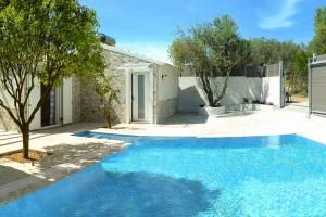 a blue swimming pool in front of a house at LUXURY JUST FOR 2 in Halikounas