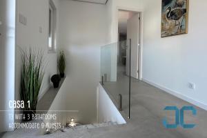 un corridoio con scala in vetro in una casa di Arada Property - 4 Houses in 1 Private Property, Free Parking and Hot Tub a Arada Altre 42 foto