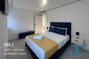 una camera da letto con un letto grande con cuscini blu di Arada Property - 4 Houses in 1 Private Property, Free Parking and Hot Tub a Arada
