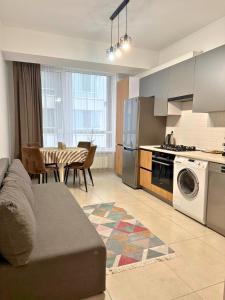 Una cocina y una sala de estar con un sofá y una mesa. en Green Park Apartment, en Chişinău
