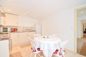 a kitchen with a table with a white table cloth at The Hayloft in Alverstone +15 photos