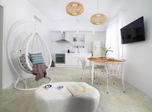 a living room with a table and a chair with a book at Votsalo Seaside in Steniaí