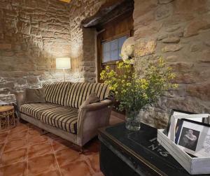 a living room with a couch and a table with flowers at Casa Rural Montedeio in Villamayor de Monjardín