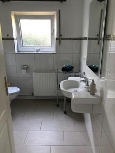 マアスホルムにあるFerienwohnung Lachs in Maasholmの洗面台、トイレ、窓のあるバスルーム +5枚の写真
