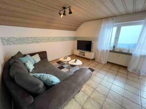 a living room with a couch and a tv at Ferienwohnung Heilsberg in Gottmadingen