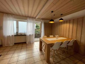 a dining room with a wooden table and chairs at Ferienwohnung Heilsberg in Gottmadingen