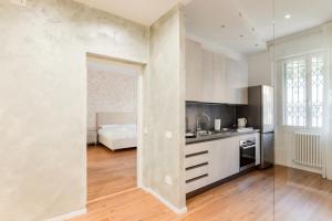 a kitchen with white walls and wooden floors at Padova living Experience - Diamante Apartment, Rubino Room and Smeraldo Room in Padova