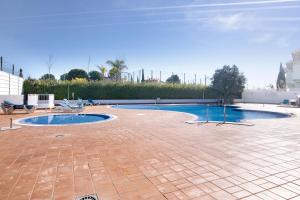 カバナス・デ・タビラにあるCosta Cabanas 54のレンガフロアのパティオにスイミングプールがあります。