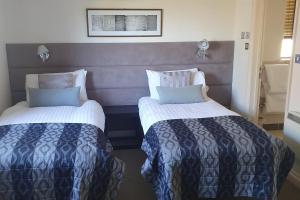 a hotel room with two beds in a room at 2br-sleeps4-pool-freeparking-trenythonestate in Par +7 photos